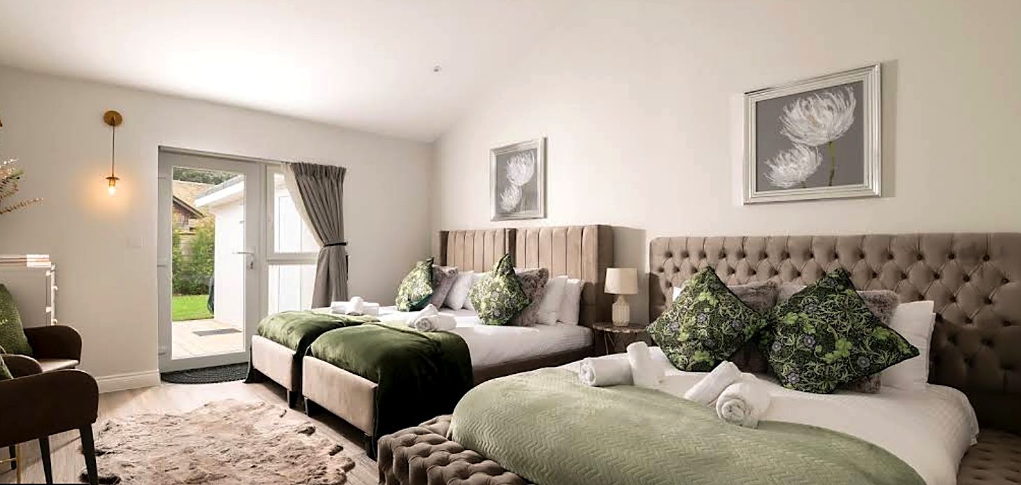 Luxury bedroom interior with vaulted ceiling, upholstered beds and garden access