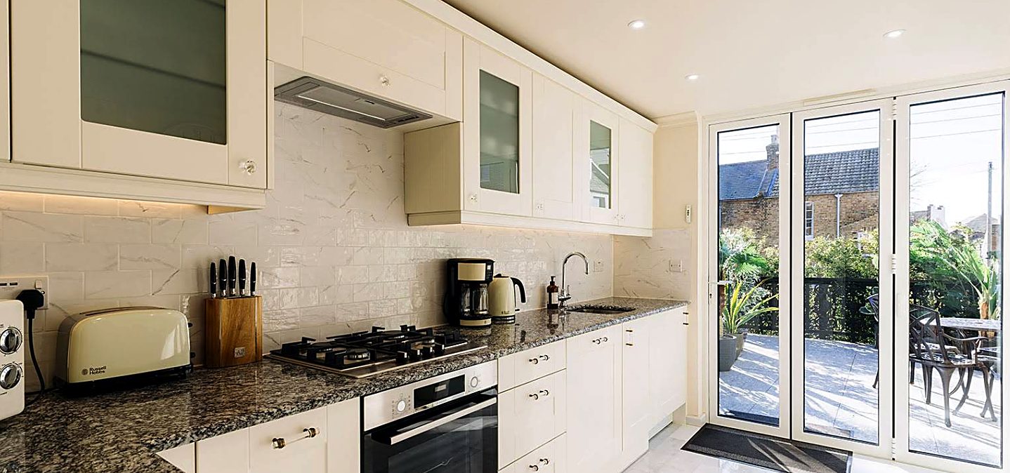 Kitchen remodel with marble splashback, granite worktops and French doors onto a terrace